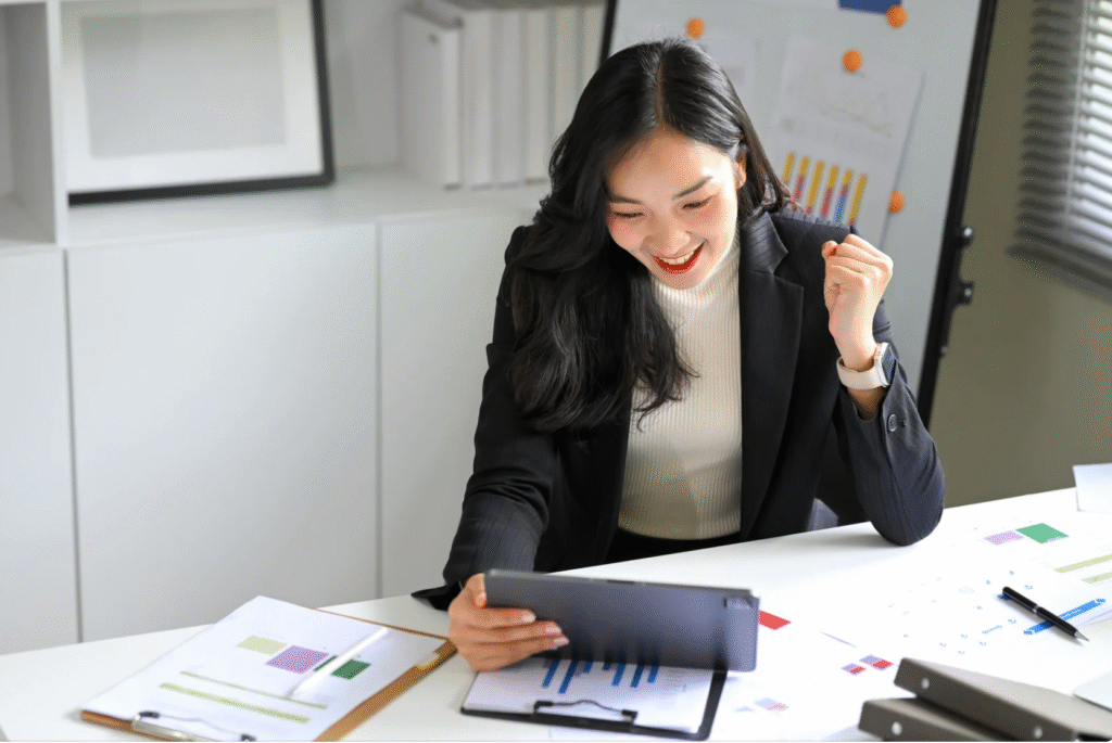Business owner smiling while reviewing digital reports on a tablet